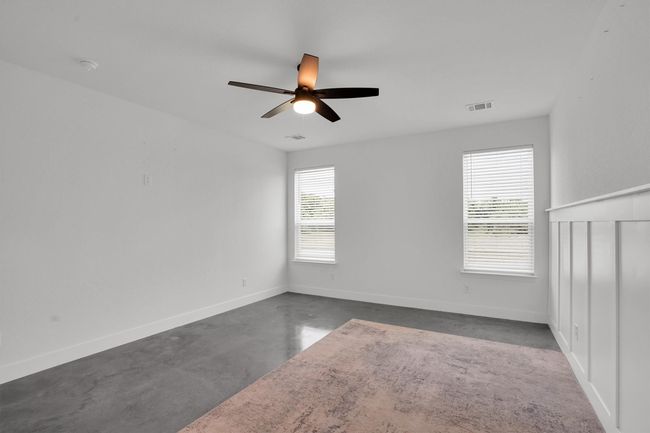 Unfurnished bedroom with finished concrete flooring, a closet, and baseboards | Image 23