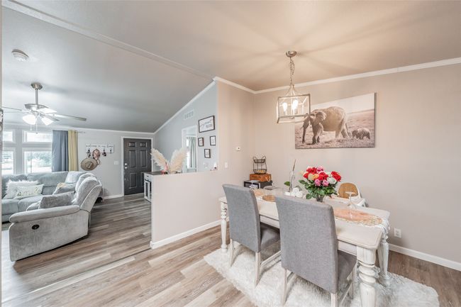 Dining area with ornamental molding, a chandelier, wood finished floors, and a ceiling fan | Image 15