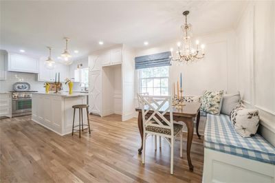 Living room with a wealth of natural light, light wood-type flooring, crown molding, and a premium fireplace | Image 1