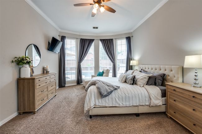 Bedroom featuring light carpet, crown molding, multiple windows, and ceiling fan | Image 28
