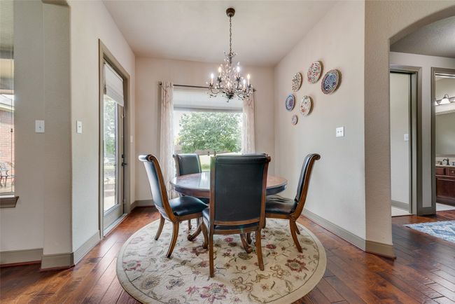 Dining room featuring hardwood / wood-style flooring, arched walkways, and a chandelier | Image 16