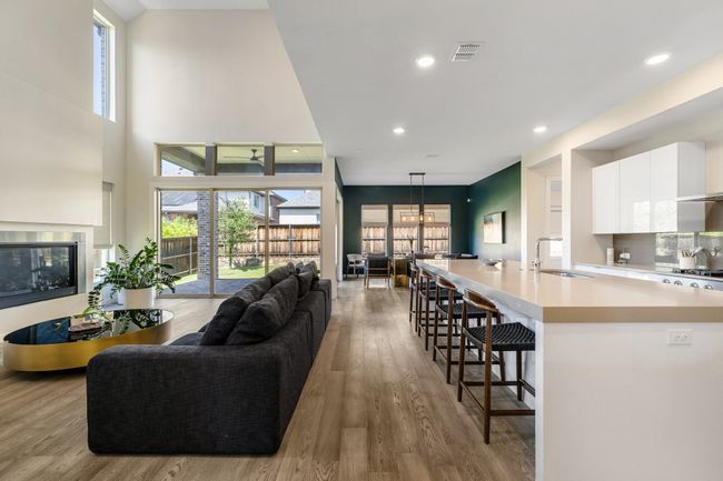 Living area with light wood finished floors, recessed lighting, and a chandelier | Image 9