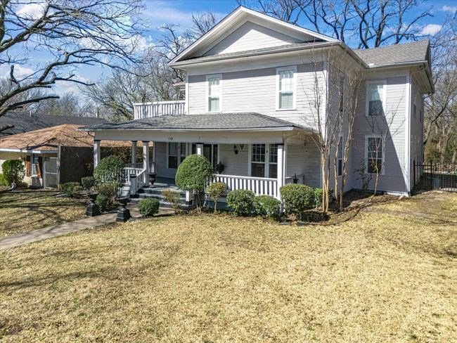 View of front of home featuring a porch and a front lawn. Note covered porch with balcony area to upper left. | Image 13