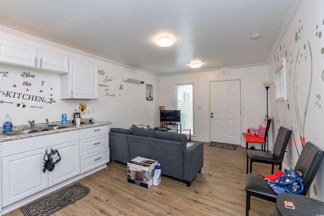 Living area featuring crown molding, a wall mounted AC, and light wood finished floors | Image 19
