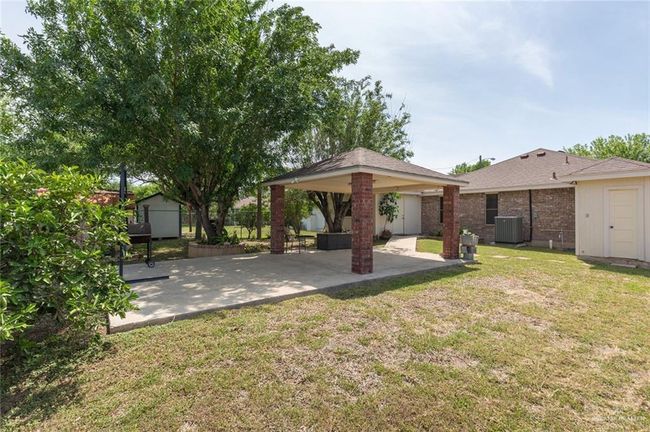 View of yard featuring a shed, a gazebo, cooling unit, an outdoor structure, and a patio area | Image 12