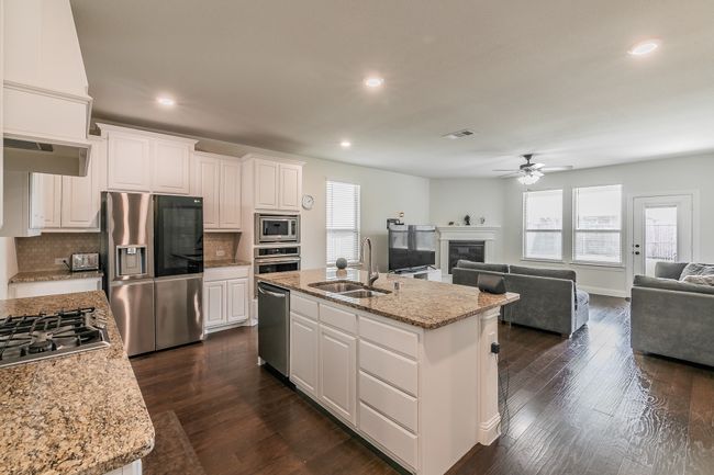Kitchen with visible vents, a sink, ceiling fan, stainless steel appliances, and open floor plan | Image 39