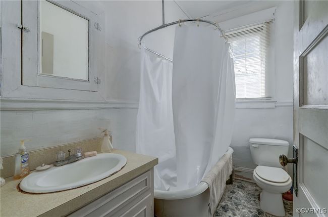 Bathroom featuring toilet, vanity, and shower / tub combo with curtain | Image 25
