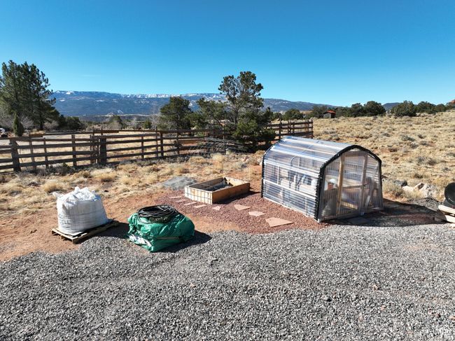 View of yard with fence, an exterior structure, a garden, an outdoor structure, and a mountain view | Image 52