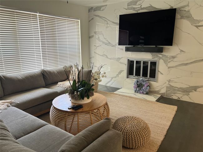 Gorgeous living room with fireplace and nice laminate wood floors. The living room furniture can stay furnished | Image 5