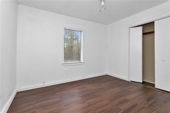 Unfurnished bedroom with dark wood-style floors, a closet, and ceiling fan | Image 25