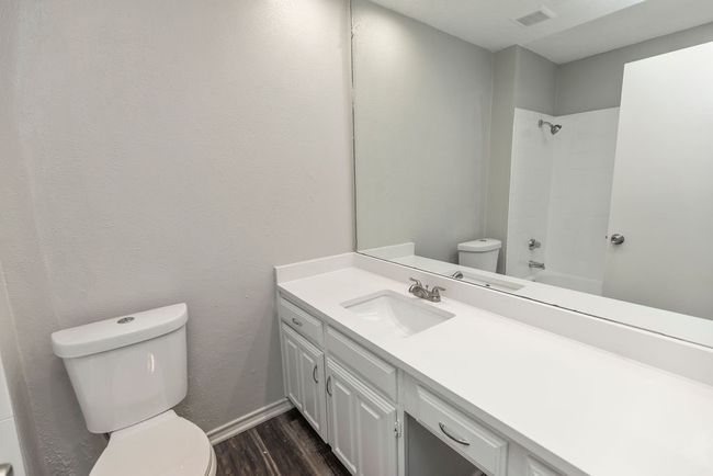 Full bathroom featuring toilet, wood finished floors, vanity, and tub / shower combination | Image 15