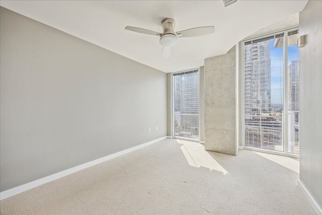 Spacious bedroom with city view. | Image 10
