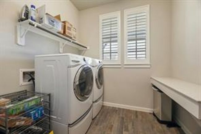 Laundry room featuring washing machine and clothes dryer and dark wood-style flooring | Image 13