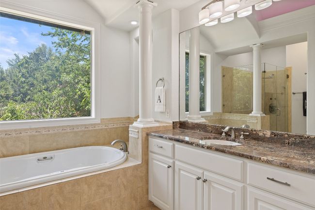 Bathroom featuring ornate columns, plenty of natural light, a stall shower, and lofted ceiling | Image 20