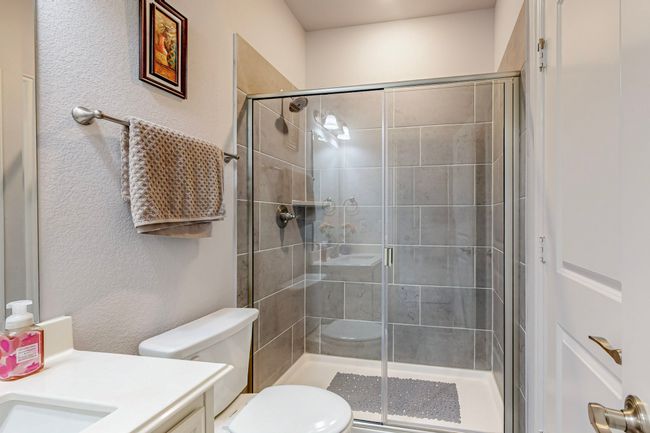 Bathroom with a stall shower, toilet, and vanity | Image 27