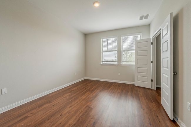 Unfurnished bedroom with visible vents, baseboards, and dark wood-style floors | Image 25