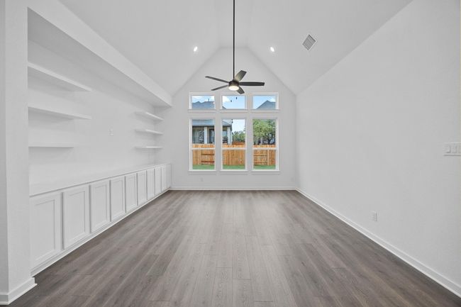 Unfurnished living room featuring dark wood finished floors, ceiling fan, and high vaulted ceiling | Image 8