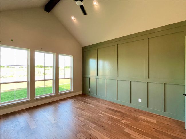Light filled master with cathedral ceiling, wood beam and accent wall. | Image 19