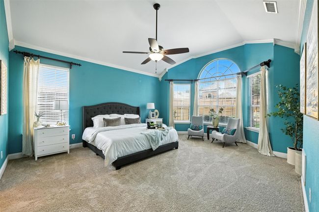 Carpeted bedroom with crown molding, vaulted ceiling, and a ceiling fan | Image 15