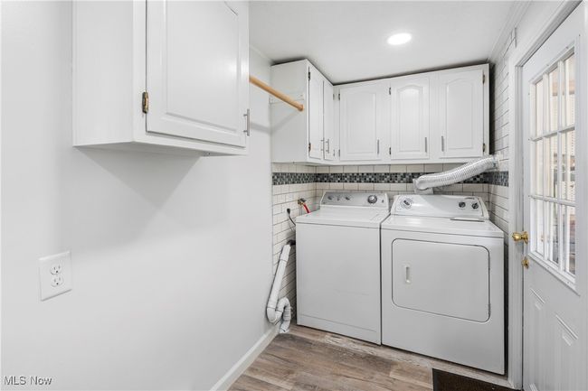 Laundry room with recessed lighting, cabinet space, washer and clothes dryer, light wood-type flooring, and baseboards | Image 25
