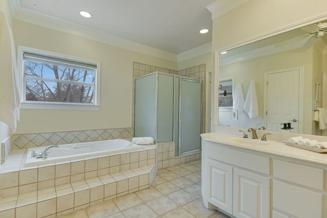 Bathroom with double vanity, crown molding, soaking tub, separate shower and two expansive walk-in closets. | Image 21