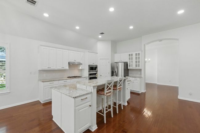 Kitchen flows into formal dining room through arched walkway. | Image 12