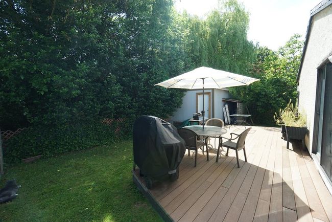 Deck with outdoor dining area, a grill, and a lawn | Image 6