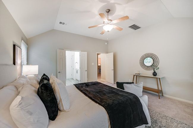 Bedroom featuring vaulted ceiling, a ceiling fan, and light colored carpet | Image 24