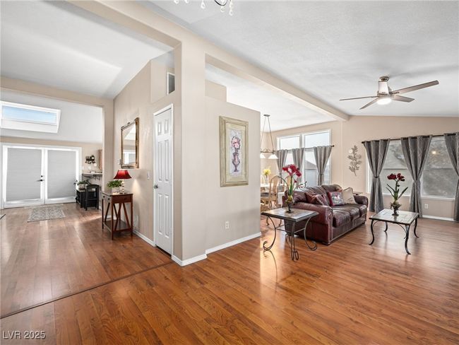Living area with baseboards, wood-type flooring, lofted ceiling, and a ceiling fan | Image 16