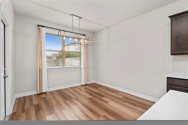 Unfurnished dining area featuring light wood-type flooring, a chandelier, and baseboards | Image 12