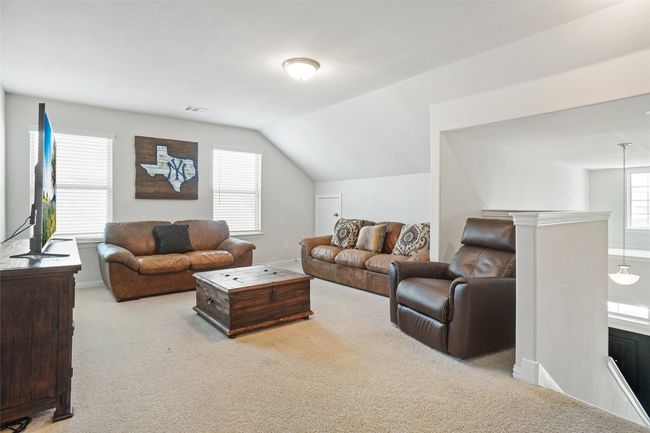 Living area with carpet floors and lofted ceiling | Image 18