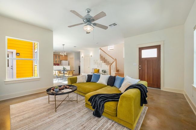 The high ceilings and stained concrete floors in the living room bring an urban edge, perfectly complimenting the open flow into the kitchen and dining areas | Image 5