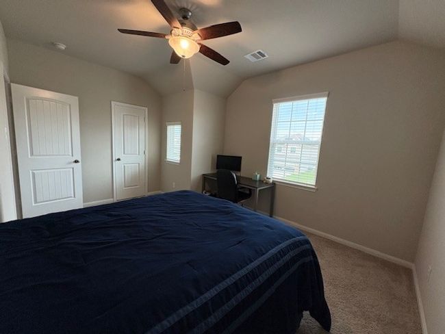 Carpeted bedroom featuring vaulted ceiling, baseboards, and a ceiling fan | Image 10