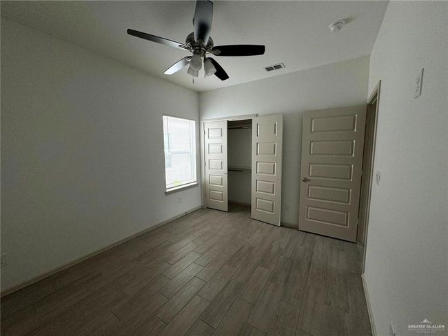 Unfurnished bedroom featuring visible vents, baseboards, wood finished floors, a closet, and a ceiling fan | Image 10