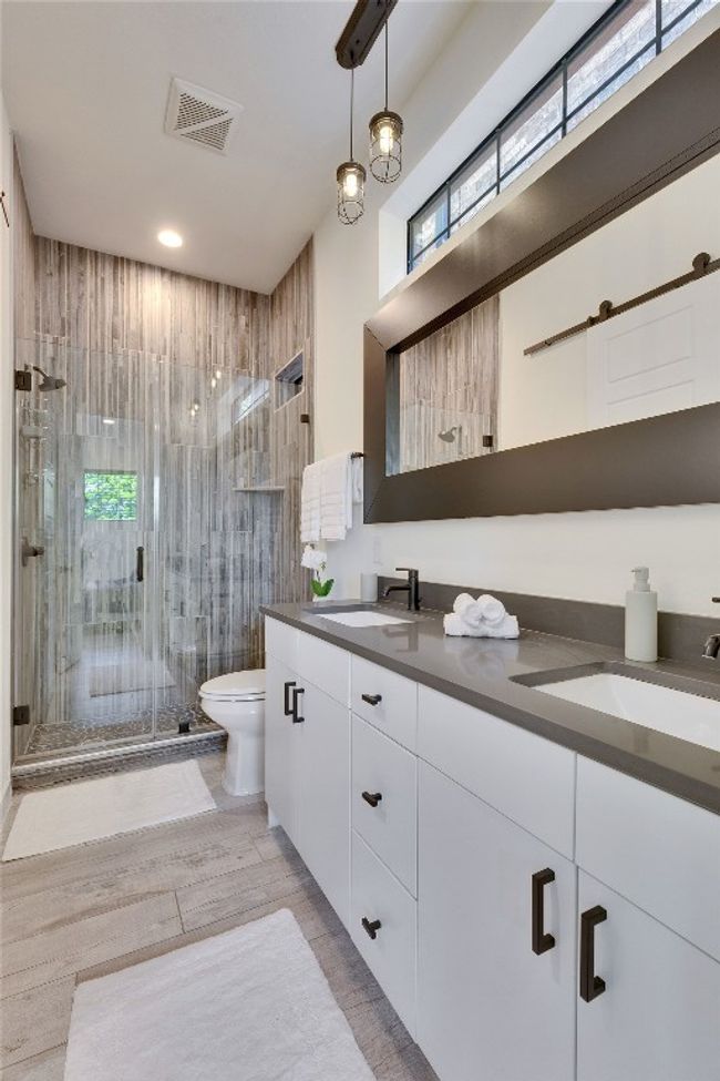 Bathroom featuring double vanity, a stall shower, and wood finished floors | Image 14