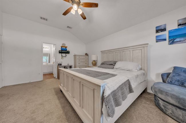 Bedroom with vaulted ceiling, light colored carpet, a ceiling fan, and ensuite bathroom | Image 11