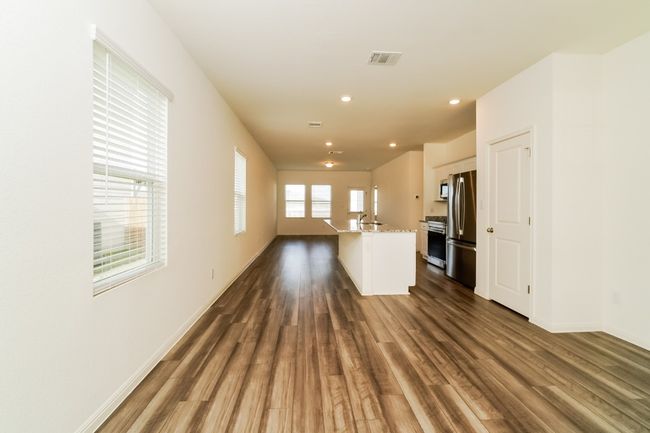 Unfurnished living room with dark wood-style floors and recessed lighting | Image 8