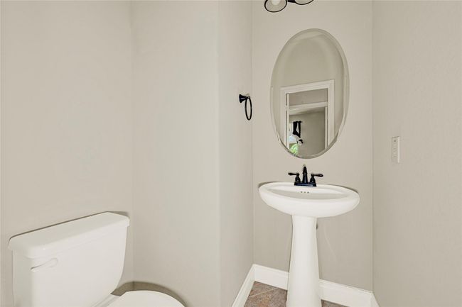 The half bath includes a pedestal sink and sleek black fixtures—an elegant touch for guests. | Image 21