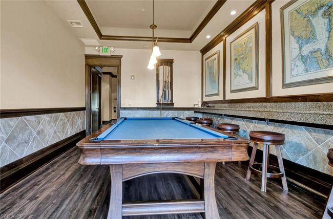 Game room featuring tile walls, a wainscoted wall, wood finished floors, a tray ceiling, and pool table | Image 45