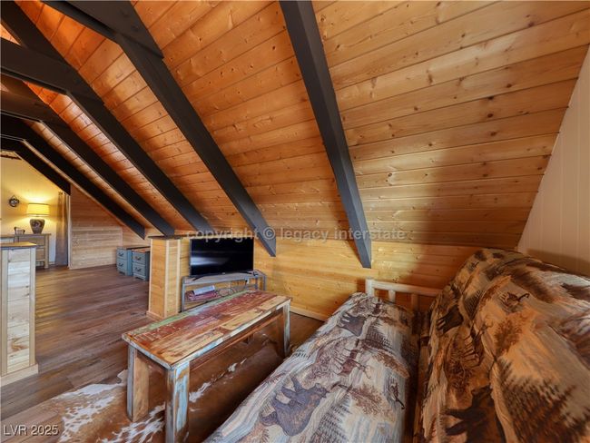 Bedroom featuring vaulted ceiling with beams, wood-type flooring, wooden walls, and wooden ceiling | Image 24