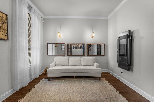 Living area with wood finished floors, crown molding, and baseboards | Image 5