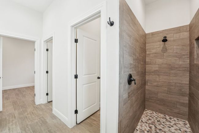 Full bath featuring a tile shower, baseboards, and wood plank tile floor | Image 22