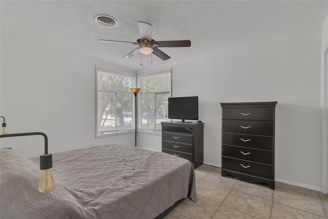 Bedroom featuring light tile patterned floors, a ceiling fan, and a textured ceiling | Image 9