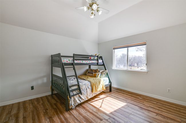 Bedroom featuring hardwood / wood-style flooring, ceiling fan, and vaulted ceiling | Image 33