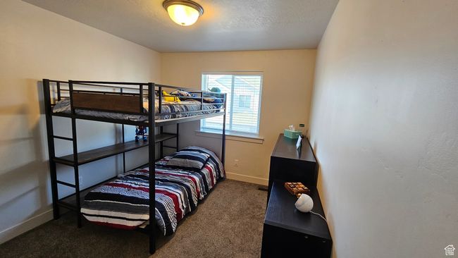 Carpeted bedroom featuring baseboards and a textured ceiling | Image 12