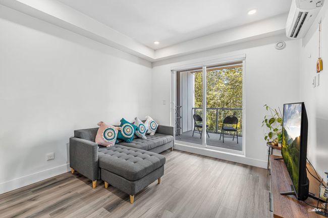 Living area featuring an AC wall unit, wood finished floors, and recessed lighting | Image 8