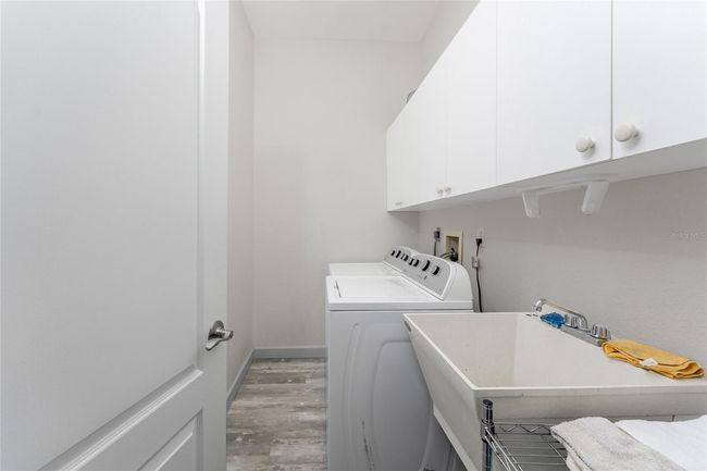 Laundry room has built cabinetry plus a utility tub. | Image 34