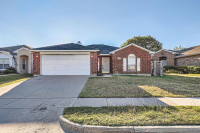 Ranch-style home with a garage and a front yard | Image 2