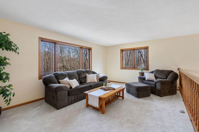 New carpet adorns the upper level, including this living room with great views of the nearly 5 acres on the Sunrise River. | Image 12