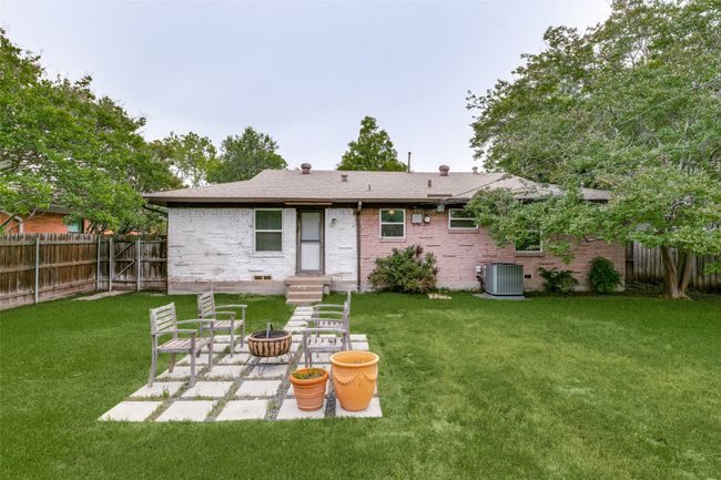 Rear view of house with brick siding, a fenced backyard, and a patio area | Image 23
